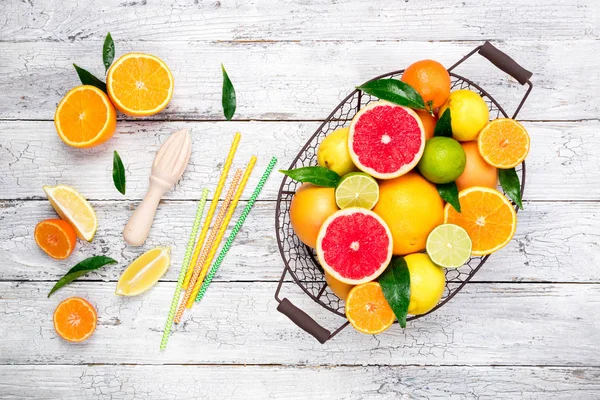 Frutas cítricas e fundo de suco de cítricos de cozinha. Frutos cítricos frescos variados com folhas. Laranja, toranja, limão, limão, tangerina na mesa de madeira — Fotografia de Stock