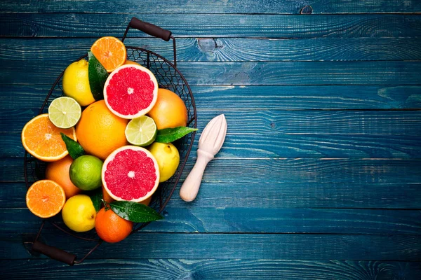 Citrus fruits and cooking citrus juice background. Assorted fresh citrus fruits with leaves. Orange, grapefruit, lemon, lime, tangerine on wooden table. Healthy eating, diet, vegetarian food concept — Stock Photo, Image