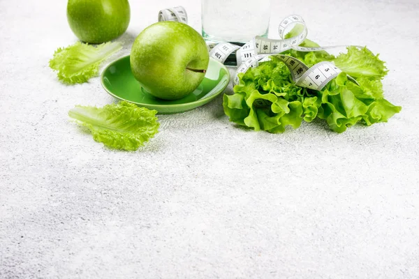 Alimentación saludable. Manzana verde, ensalada de lechuga, vaso de agua, cinta métrica. Concepto de dieta, adelgazamiento, pérdida de peso y planificación de comidas. Vista superior — Foto de Stock