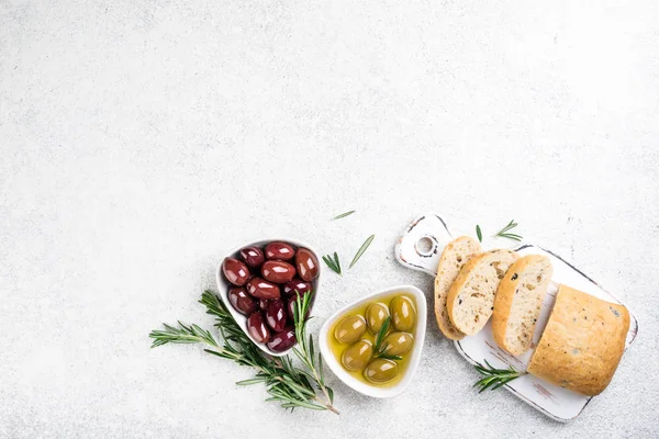 Pão de Ciabatta, azeitonas, óleo, ervas sobre fundo branco. Lanches mediterrânicos — Fotografia de Stock