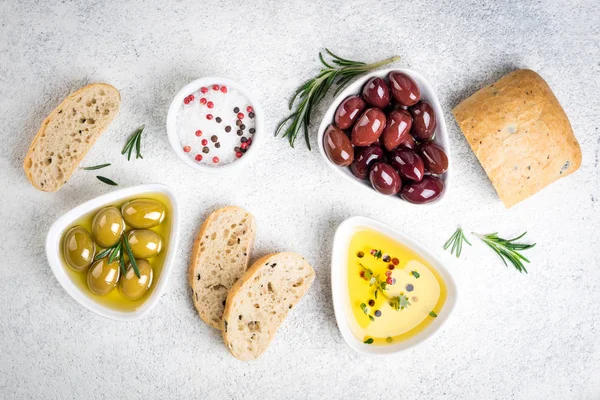 Lanches mediterrânicos. Pão de Ciabatta, azeitonas, óleo, ervas e especiarias sobre fundo branco — Fotografia de Stock