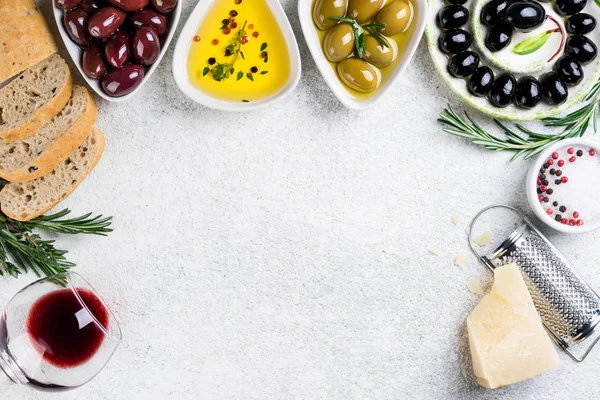Azeitonas, pão ciabatta, vinho tinto, queijo, óleo, ervas e especiarias sobre fundo branco. Lanches mediterrânicos — Fotografia de Stock