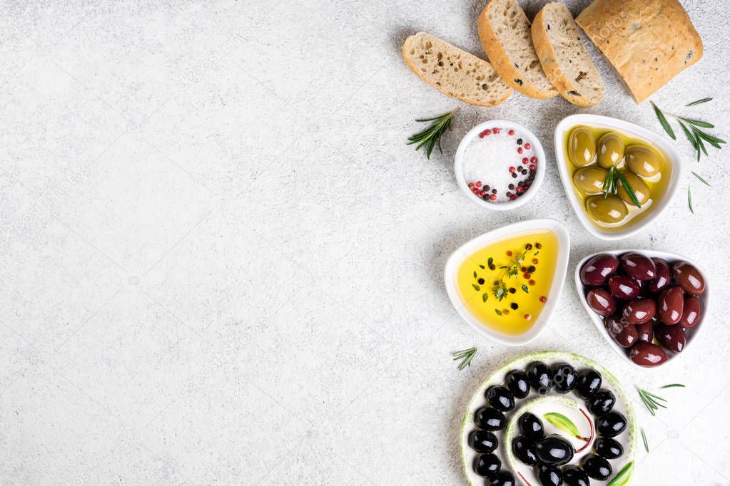 Ciabatta bread, olives, cheese, oil, herbs and spices on white background. Mediterranean snacks. Copy space