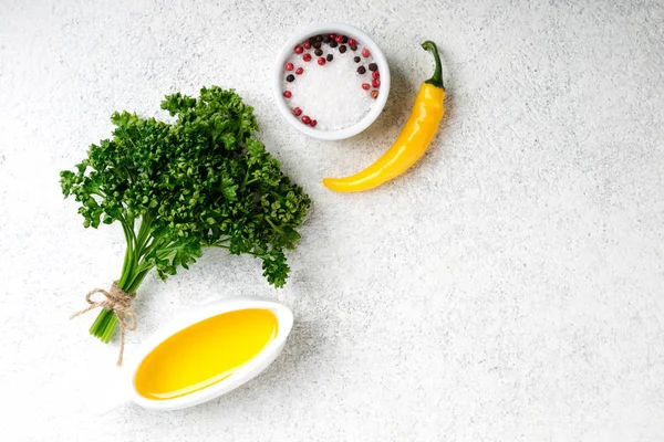 Sfondo di erbe e spezie. Condimento prezzemolo fresco, sale, pepe, olio d'oliva e peperoncino giallo su fondo di cemento bianco. Cibo vegetariano sfondo — Foto Stock