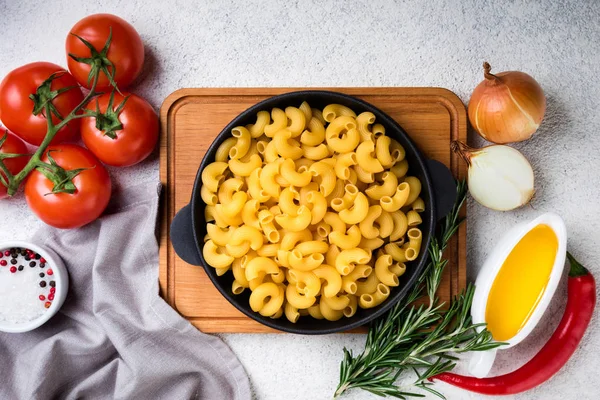Massa e ingredientes para cozinhar em fundo branco. Conceito de comida italiana. Massas alimentícias, tomates, manjericão, legumes e especiarias — Fotografia de Stock