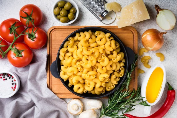 Massa e ingredientes para cozinhar em fundo branco. Conceito de comida italiana. Massas alimentícias, tomates, manjericão, legumes e especiarias — Fotografia de Stock