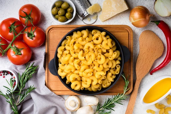 Pasta and ingredients for cooking on white background. Italian food concept. Pasta, tomatoes, basil, vegetables and spices — Stock Photo, Image