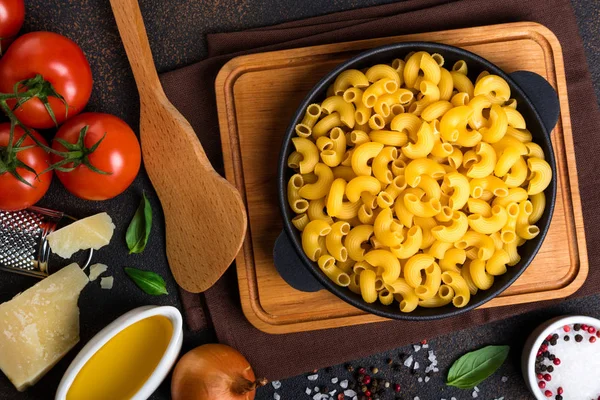 Pasta and ingredients for cooking on black background.Italian food concept. Pasta, tomatoes, basil, vegetables and spices — Stock Photo, Image