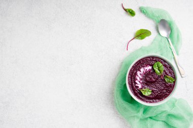 Pancar çorbası kase beyaz taş zemin üzerine krem. Pazı yaprakları ile pancar püresi Detoks