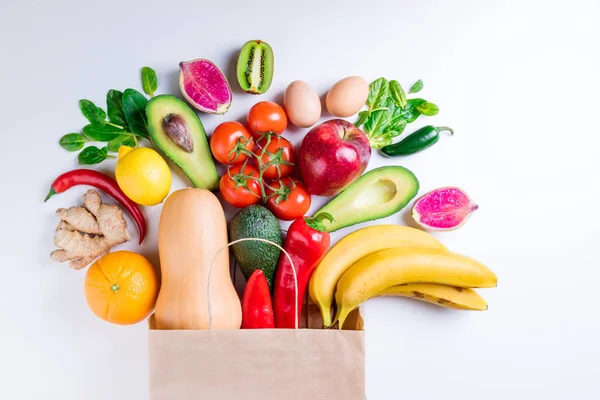 Fondo alimentario saludable. Comida saludable en bolsa de papel frutas y verduras en blanco. Comida vegetariana. Compras concepto de supermercado de alimentos — Foto de Stock