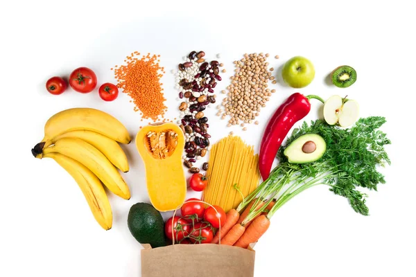 Tło zdrowej żywności. Zdrowe wegetariańskie jedzenie w papier torba makaron, warzywa i owoce na białym. Zakupy żywności koncepcji — Zdjęcie stockowe
