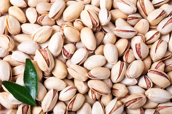 Pistachios background. Pistachio texture with leaves. Nuts — Stock Photo, Image