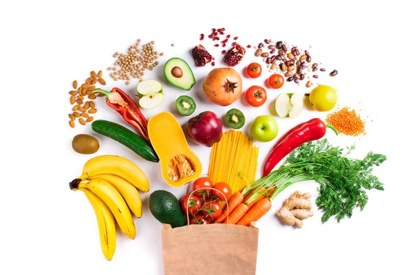 Fondo alimentario saludable. Comida vegetariana saludable en pasta bolsa de papel, verduras y frutas en blanco vista superior. Comida de compras — Foto de Stock