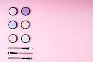 Kozmetik ürünleri, makyaj göz göz farı ve aksesuarları üzerinde pembe bir arka plan düz için yatıyordu. Moda ve güzellik bloglama kavramı. Üstten görünüm, kopya alanı