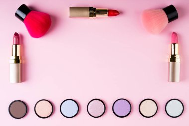 Çerçeve makyaj ürünleri ve Dekoratif kozmetik pembe bir arka plan düz üzerinde yatıyordu. Moda ve güzellik bloglama kavramı. Üstten Görünüm, kopya alanı