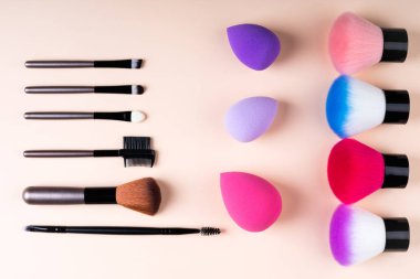 Bej renkli arka plan düz makyaj Kozmetik aksesuarlar yatıyordu. Kozmetik fırçalar kümesi. En az kompozisyon. Moda ve güzellik bloglama kavramı. Üstten Görünüm, kopya alanı