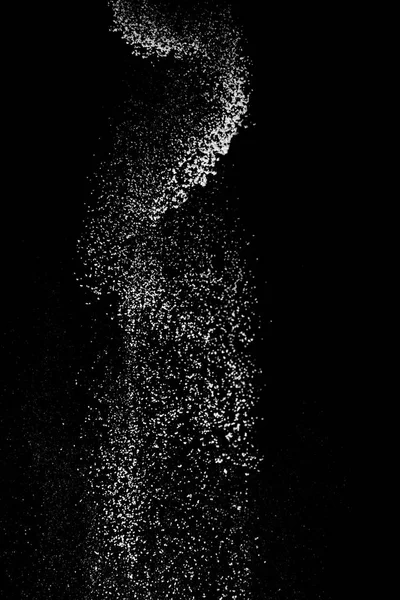 White powder splash isolated on black background. Flour sifting on a black background. Explosive powder white