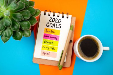 2020 yılbaşı hedefleri masada. 2020 gol listesi, renkli arkaplanlı kahve fincanı. Hedef, çözümler, plan, strateji, değişim, fikir kavramı. 