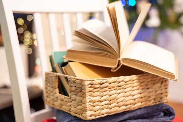 Старые книги и открытая книга на праздничном боке фоне. Чтение, уютный дом, отдых, праздники — стоковое фото