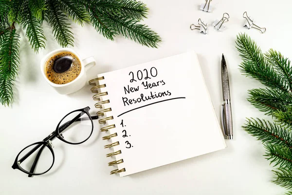 Resoluções de ano novo 2020 na mesa. 2020 lista de metas com caderno, xícara de café, árvore de natal e óculos em fundo branco. Objetivo, plano, estratégia, mudança, conceito de ideia — Fotografia de Stock