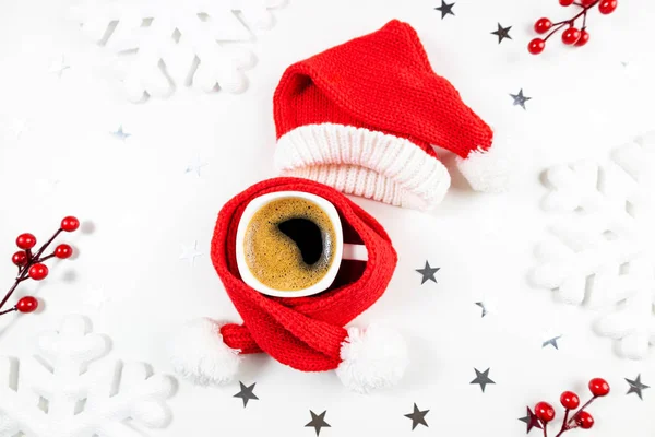 Composizione natalizia invernale con tazza di caffè su sfondo bianco. Tazza di caffè con cappello rosso di Babbo Natale e sciarpa. Natale, nuovo anno, vacanza, bevanda di caffè festiva — Foto Stock