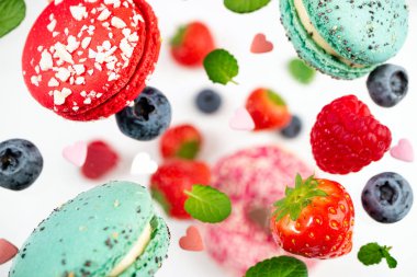 Beyaz arka planda kurabiye ve böğürtlen düşmesi. Yaban mersinleri ve Fransız pastaları arasında uçmak.