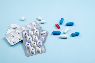 Mavi arka planda gülen yüzlü komik haplar. Sağlık, günlük ilaçlar, antidepresanlar, ilaçlar, tedavi konsepti. Boşluğu kopyala