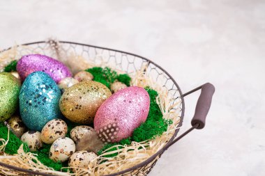 Paskalya kompozisyonu ve renkli paskalya yumurtaları sepette. Bahar tatili için Paskalya kartı. Üst görünüm, alanı kopyala