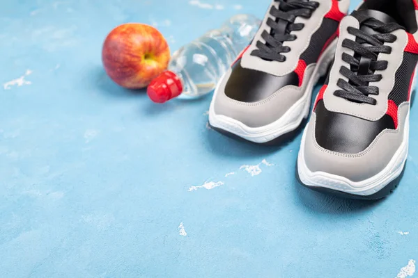 Sapatos Desportivos Maçã Garrafa Água Sobre Fundo Azul Conceito Estilo — Fotografia de Stock