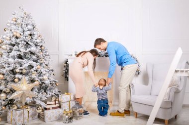 Noel ağacı yakınındaki genç aile ayakta