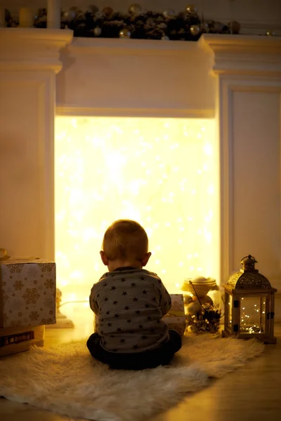 Mały chłopiec siedzi na prezenty świąteczne — Zdjęcie stockowe
