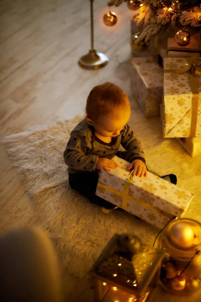 Mały chłopiec siedzi na prezenty świąteczne — Zdjęcie stockowe