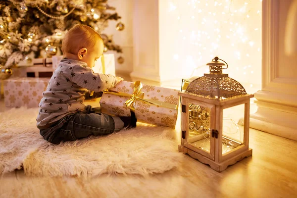 küçük çocuk bir Noel ağacı oturan