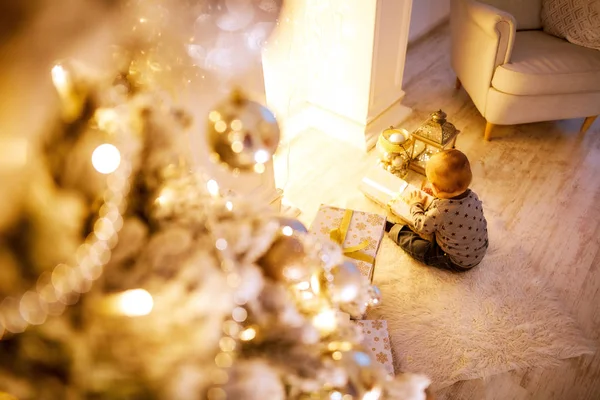 küçük çocuk bir Noel ağacı oturan