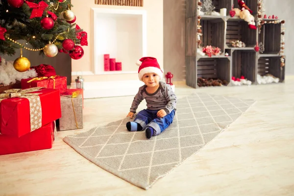 küçük çocuk bir Noel ağacı oturan