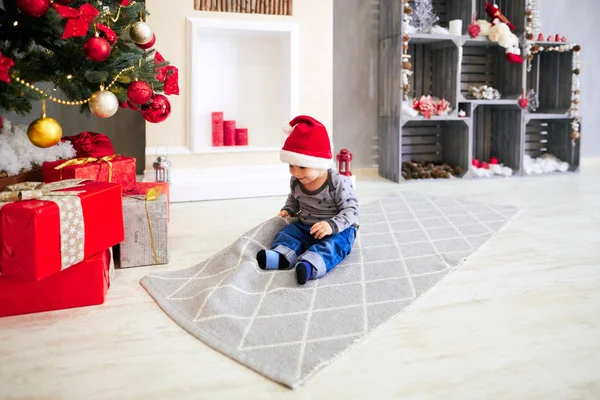 küçük çocuk bir Noel ağacı oturan