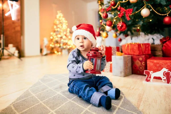 küçük çocuk bir Noel ağacı oturan