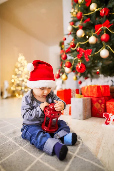 küçük çocuk bir Noel ağacı oturan