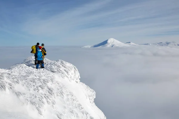 En grupp vandrare står på kanten av berget — Stockfoto