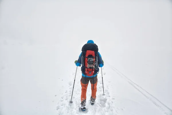 背着背包和雪鞋在雾中走在小径上的游客 — 图库照片