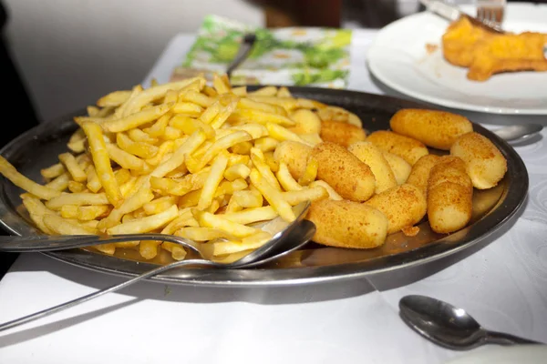 French fries and croquettes on plate in restaurant