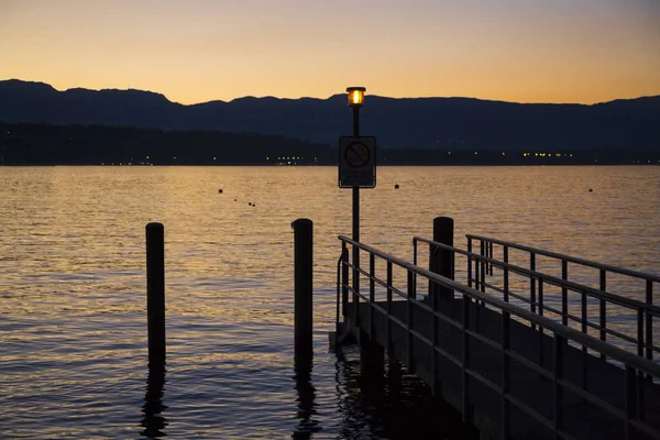 Pôr do sol laranja e molhe no Lago de Genebra — Fotografia de Stock