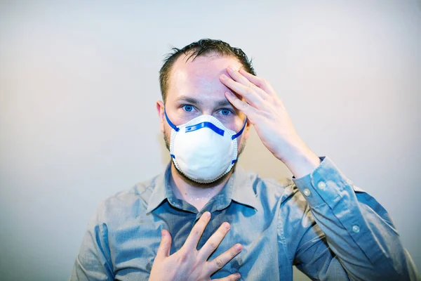 Человек с реальными симптомами коронавируса COVID-19 носит защитную маску — стоковое фото