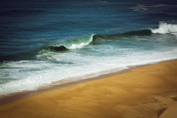 Вид с воздуха на песчаный северный пляж и Атлантический океан с большими волнами в Назаре, Португалия — стоковое фото