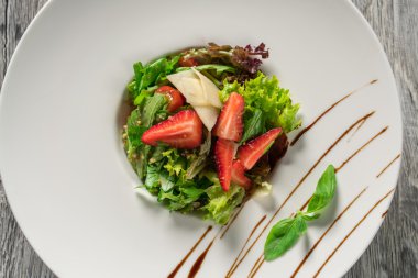 Yeşil salata, peynir ve çilek balzamik sos ile.