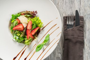 Yeşil salata, peynir ve çilek balzamik sos ile.
