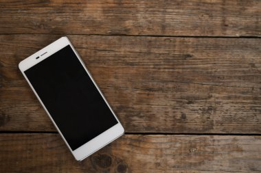 boş ekran ahşap masanın üzerinde yatan ile akıllı telefon.
