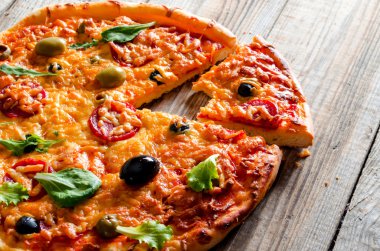 Ev yapımı pizza ahşap arka plan üzerinde.