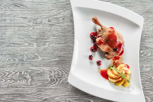 Beyaz tabakta ördek bacak confit sağlıklı bir kahvaltı ile karamelize elma