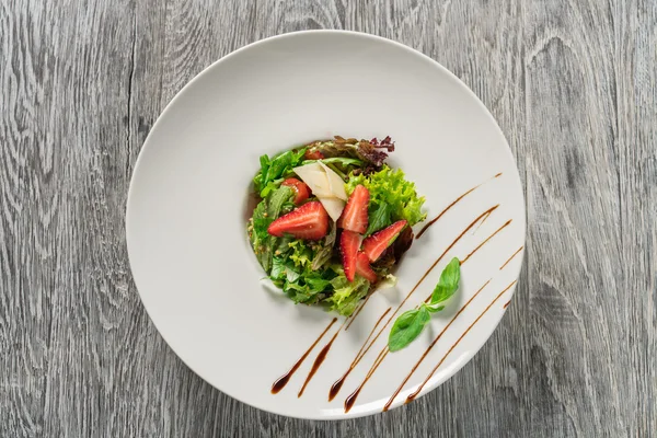 Yeşil salata, peynir ve çilek balzamik sos ile.